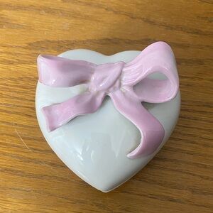 A vintage Houbigant heart-shaped ceramic trinket box with a pink bow.